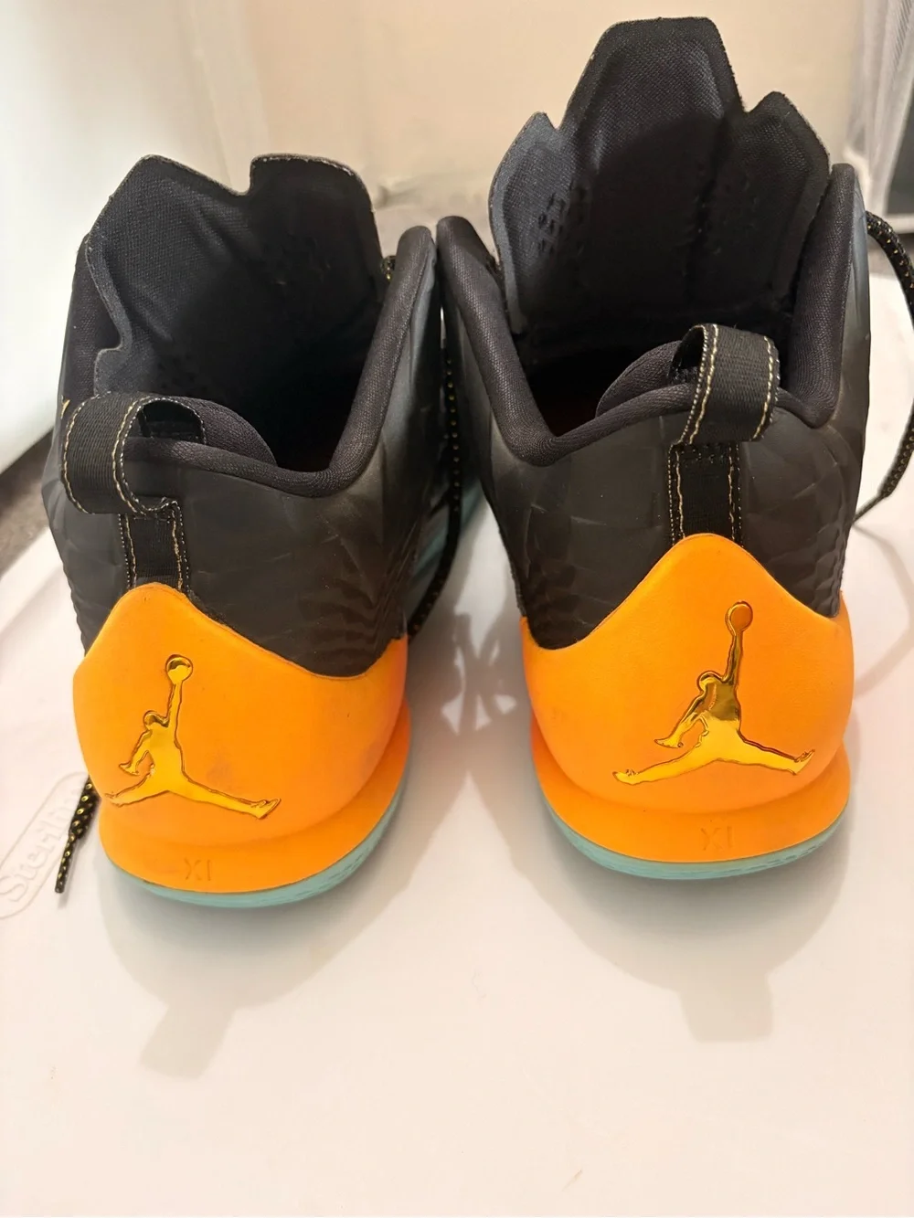 Jordan Melos Mens Black High-Top Sneakers with Orange Heel and Teal Sole